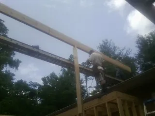 Carpenter setting a ridge beam over a new addition frame — Ice Dam Removal by Roofing Brothers in Gwinner