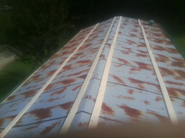Rusted metal roof panels with new wood purlins before replacement — Storm Damage Roof Repair in Gwinner by Roofing Brothers