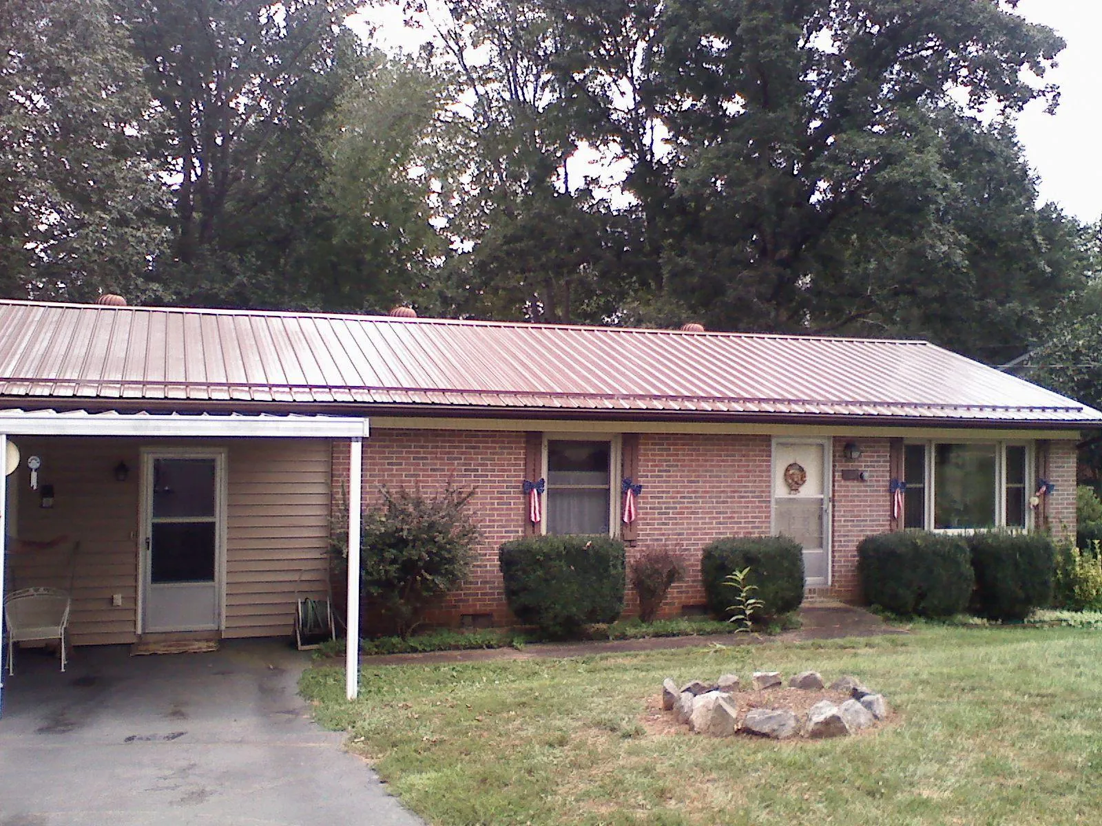 Bronze metal roof and carport on a brick ranch home — Roof Repair work by our crew in Gwinner